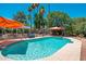 Beautiful swimming pool area with lounge seating and orange umbrellas at 14622 N 45Th Pl, Phoenix, AZ 85032