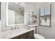 Stylish bathroom with a vanity, illuminated mirror, walk-in shower, and built-in shelving at 14885 W Ashland Ave, Goodyear, AZ 85395