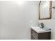 Neutral powder room featuring a pedestal sink, framed mirror, and updated fixtures at 14885 W Ashland Ave, Goodyear, AZ 85395