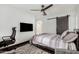 Primary bedroom features a sliding barn door, ceiling fan, and laminate flooring at 14885 W Ashland Ave, Goodyear, AZ 85395