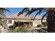 Backyard featuring a covered patio, pool, and lush landscaping with mature palm trees at 15861 W Westview Dr, Goodyear, AZ 85395
