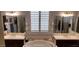 Bright bathroom featuring dual sinks, a soaking tub, and decorative seashell accents at 15861 W Westview Dr, Goodyear, AZ 85395