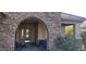 Stone archway frames the front door, complemented by outdoor seating and landscaping at 15861 W Westview Dr, Goodyear, AZ 85395