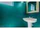 Stylish powder room with modern pedestal sink and vibrant turquoise walls at 16626 N 20Th St, Phoenix, AZ 85022