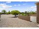 Expansive backyard with decorative gravel, mature trees, and lush landscaping for serene outdoor living at 17009 W Eureka Springs Dr, Surprise, AZ 85387
