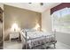 Cozy bedroom featuring a decorative metal frame bed with side tables and a window at 17009 W Eureka Springs Dr, Surprise, AZ 85387