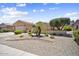 Beautiful single-story house featuring a xeriscaped front yard with mature trees and desert landscaping at 17009 W Eureka Springs Dr, Surprise, AZ 85387