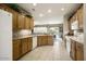 Well-lit kitchen featuring ample cabinet space, tile flooring, and a view into the dining area at 17009 W Eureka Springs Dr, Surprise, AZ 85387