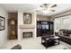 Cozy living room with fireplace, large windows, and comfortable seating at 17009 W Eureka Springs Dr, Surprise, AZ 85387