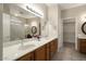 Elegant main bathroom featuring dual sinks, a large mirror, and walk-in closet at 17009 W Eureka Springs Dr, Surprise, AZ 85387