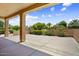 Covered patio with view of landscaped backyard with shrubs and trees at 17009 W Eureka Springs Dr, Surprise, AZ 85387
