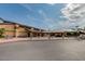 A clubhouse featuring desert landscaping, architectural design elements, and parking for cars and golf carts at 17200 W Bell Rd # 2162, Surprise, AZ 85374
