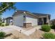 Home exterior showcasing a two-car garage, low-maintenance landscaping, and neutral stucco facade at 17338 W Via De Luna Dr, Surprise, AZ 85387