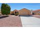 Charming single-story home featuring a two-car garage and desert landscaping with a beautiful green tree at 17910 N 92Nd Ln, Peoria, AZ 85382