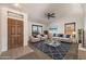 Inviting living room features a stylish rug, comfortable seating, and bright natural light from the window at 17910 N 92Nd Ln, Peoria, AZ 85382