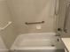 Bathroom featuring a white tiled tub and handrails at 1825 W Ray Rd # 1008, Chandler, AZ 85224