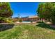 Expansive backyard view of the fenced pool, grassy area, and the home's exterior at 19206 N 40Th St, Phoenix, AZ 85050