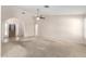 Open-concept living room with neutral carpet, a ceiling fan, and large windows for natural light at 19206 N 40Th St, Phoenix, AZ 85050