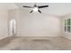 Neutral-toned living area with a ceiling fan, carpet flooring, and archway, creating a welcoming space at 19206 N 40Th St, Phoenix, AZ 85050