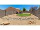Backyard featuring desert landscaping, rock features, and green, manicured grass at 2018 N 104Th Dr, Avondale, AZ 85392