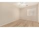 A bright bedroom with a ceiling fan, large window, and wood-style flooring at 2018 N 104Th Dr, Avondale, AZ 85392