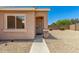 Front exterior showcasing entryway, security door, desert landscaping, and an adjacent window at 2018 N 104Th Dr, Avondale, AZ 85392