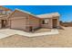 Front exterior of home with gravel landscaping, a two-car garage and tiled roof at 2018 N 104Th Dr, Avondale, AZ 85392