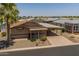 Exterior view of charming single-story home with carport, gravel yard, and palm tree at 2263 N Trekell Rd # 159, Casa Grande, AZ 85122