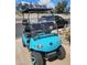 Front view of a turquoise golf cart with black trim and custom wheels, parked on a concrete driveway at 2263 N Trekell Rd # 159, Casa Grande, AZ 85122