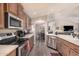 Modern kitchen features stainless steel appliances, updated cabinetry, an island, and sleek flooring, connecting to the dining area at 2263 N Trekell Rd # 159, Casa Grande, AZ 85122