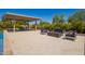 Backyard patio with covered dining area, an outdoor seating arrangement, a fire pit, and lush landscaping at 24840 S 195Th St, Queen Creek, AZ 85142
