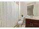 Bright bathroom featuring a vanity with dark wood cabinets and a shower with a patterned curtain at 24840 S 195Th St, Queen Creek, AZ 85142
