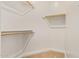 Walk-in closet with carpet and wood rods and white supports for storing clothes, shoes, and accessories at 24840 S 195Th St, Queen Creek, AZ 85142