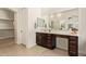 Bright main bathroom with double vanity, large mirror, walk-in closet and tiled floors at 24840 S 195Th St, Queen Creek, AZ 85142