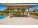 Covered patio with stone flooring, dining table, ceiling fan, outdoor kitchen and access to the pool at 24840 S 195Th St, Queen Creek, AZ 85142