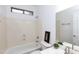 Bathroom with a tub and shower combination, a large mirror, and neutral tiling at 2527 E Remington Pl, Chandler, AZ 85286