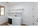 Well-lit laundry room with modern appliances, a utility sink, and upper shelving at 2527 E Remington Pl, Chandler, AZ 85286