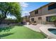 Well-maintained backyard with artificial turf, built-in fire pit, and basketball court at 2541 E Carob Dr, Gilbert, AZ 85298