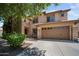 Beautiful home featuring a manicured lawn, stone accents, and a spacious driveway and garage on a sunny day at 2541 E Carob Dr, Gilbert, AZ 85298