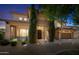 Inviting two-story home with meticulously landscaped front yard and charming architectural details at twilight at 2541 E Carob Dr, Gilbert, AZ 85298
