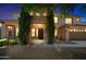 Charming two-story home at dusk with a well-manicured front yard and stone accents on the entrance at 2541 E Carob Dr, Gilbert, AZ 85298