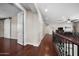 Upstairs hallway with hardwood floors, white doors, and iron railing overlooking the foyer at 2541 E Carob Dr, Gilbert, AZ 85298