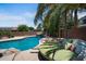 Backyard pool featuring a rock waterfall and surrounded by lush tropical landscaping at 2541 E Carob Dr, Gilbert, AZ 85298