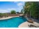 Beautiful backyard pool with waterfall feature and lush landscaping at 2541 E Carob Dr, Gilbert, AZ 85298