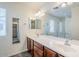 Bathroom with double sinks, wood cabinets, large mirror, and a view of the walk-in closet and shower at 26505 N Babbling Brook Dr, Phoenix, AZ 85083