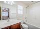 A well-lit bathroom featuring a shower, window, and vanity with a dark wood finish at 26505 N Babbling Brook Dr, Phoenix, AZ 85083