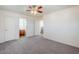 A neutral bedroom with a ceiling fan, carpeted floors, and access to the bathroom at 26505 N Babbling Brook Dr, Phoenix, AZ 85083