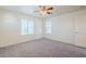 A carpeted bedroom with a ceiling fan and three windows at 26505 N Babbling Brook Dr, Phoenix, AZ 85083