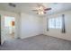 This is a bedroom featuring plush gray carpet, neutral walls, and a ceiling fan at 26505 N Babbling Brook Dr, Phoenix, AZ 85083