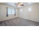Spacious bedroom with neutral carpet, ceiling fan and natural light from windows at 26505 N Babbling Brook Dr, Phoenix, AZ 85083